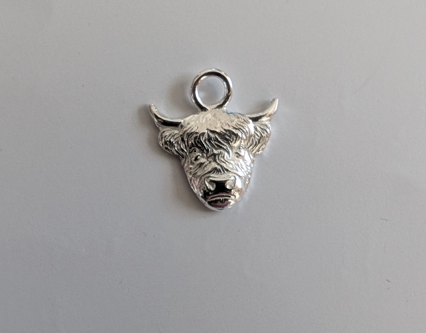 Highland Cow Charm Earrings handmade from fine silver on a small sterling silver hoop or hook