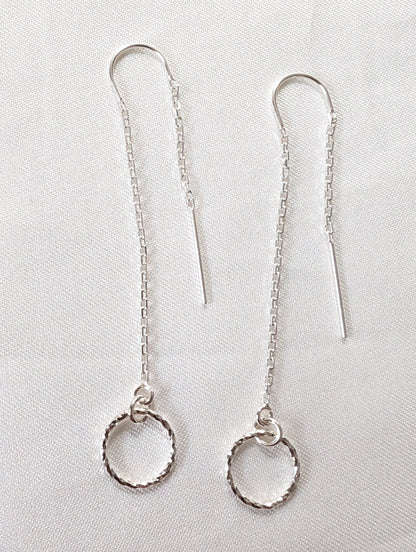 A pair of sterling silver threader earrings with sparkly circle charms and U bar to ensure threader dangles both sides of the ear.