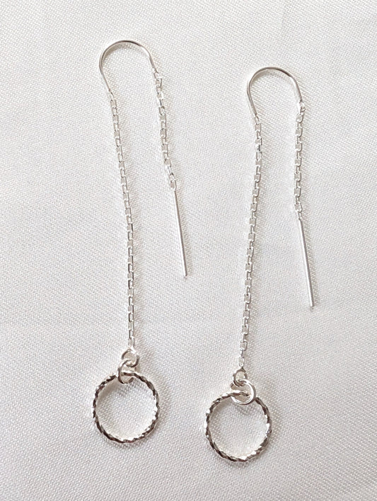 A pair of sterling silver threader earrings with sparkly circle charms and U bar to ensure threader dangles both sides of the ear.