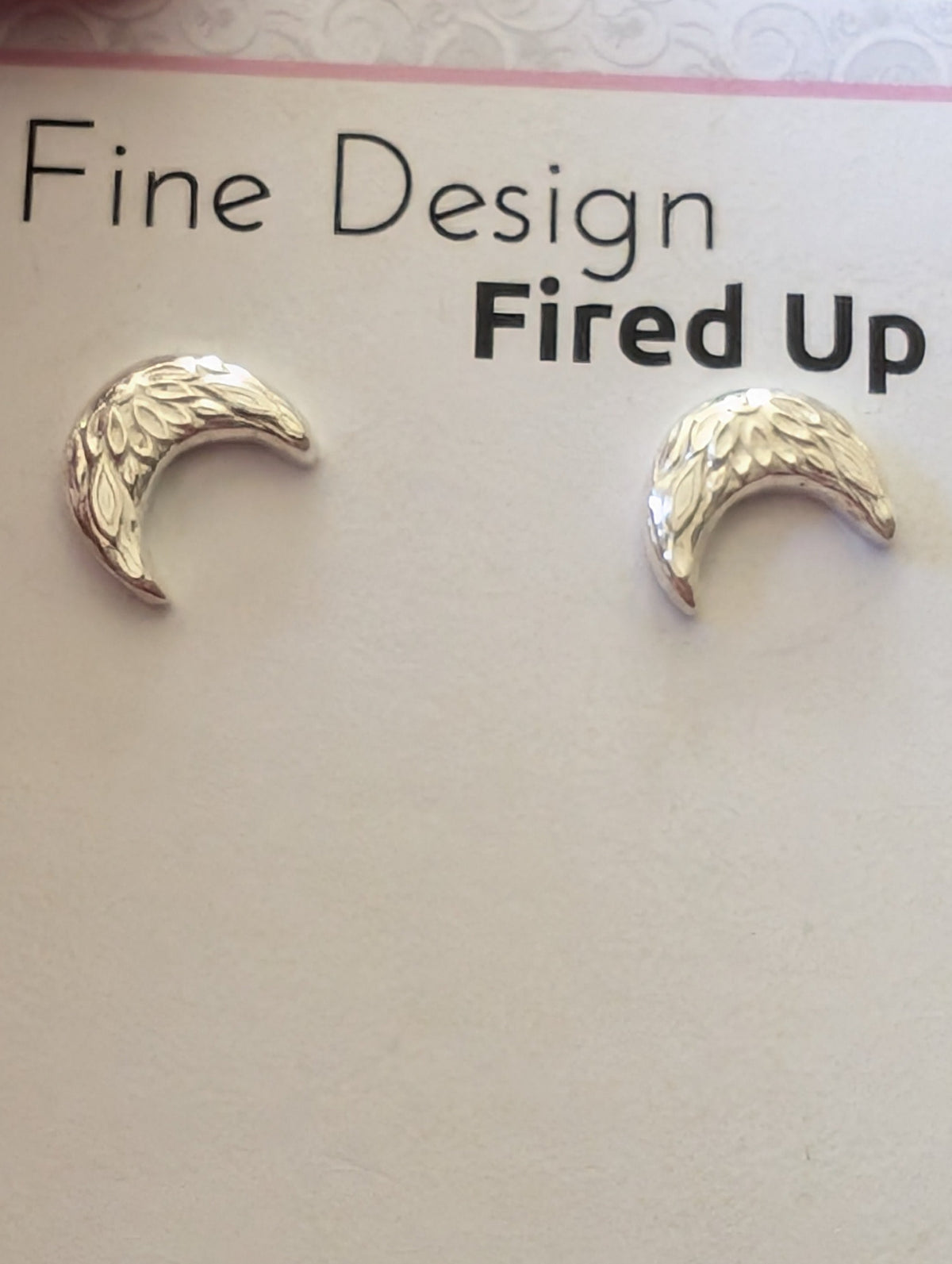 Sterling silver crescent moon earrings on backing card
